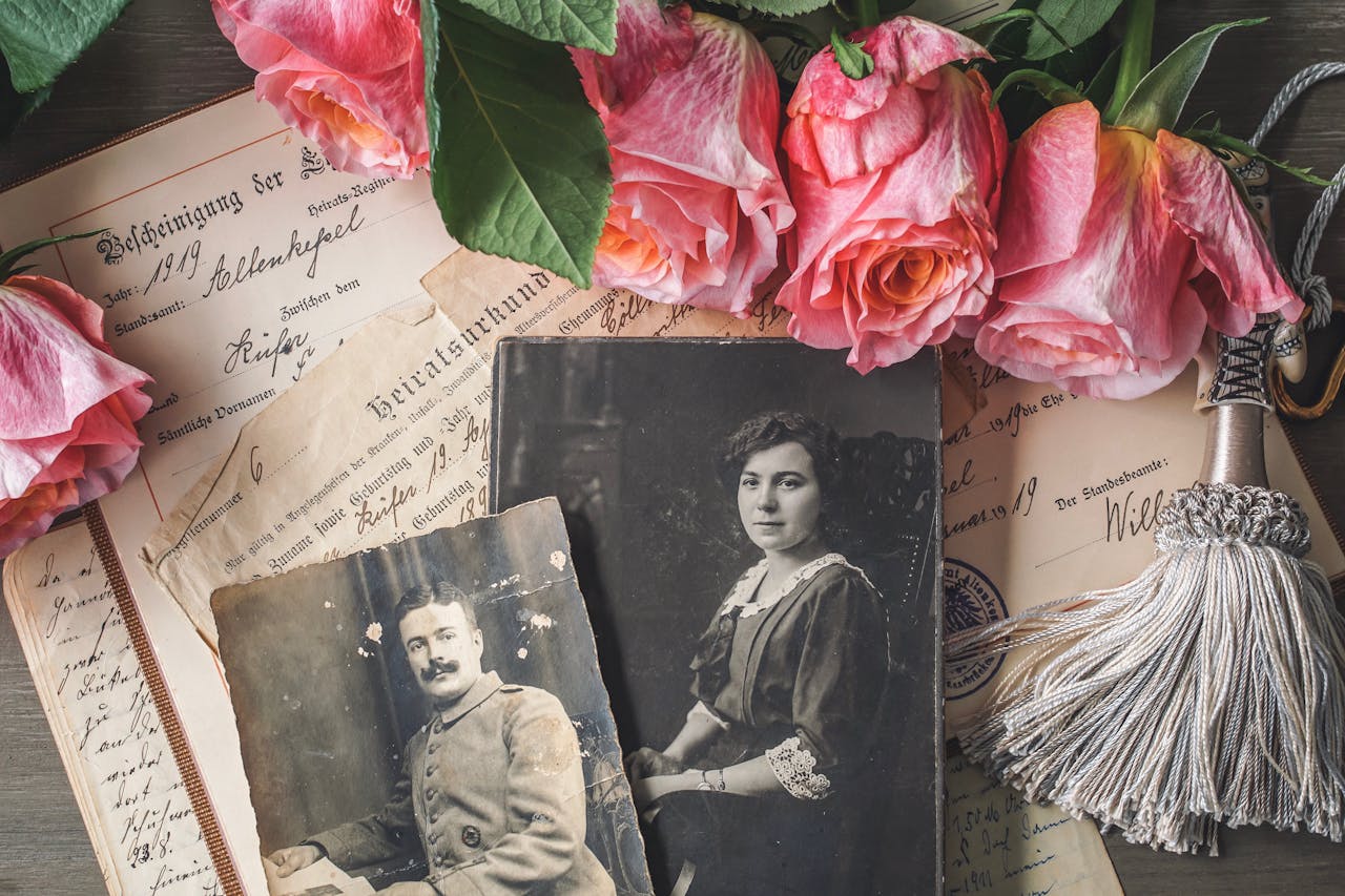 embark Antique family photographs with pink roses and historic documents.